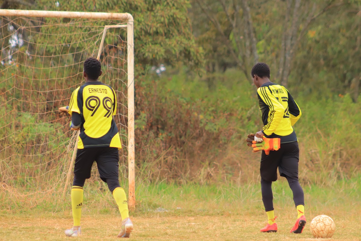 Goalkeepers getting ready for play on the club football field